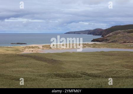 Sandwood Bay est une large bande de sable sauvage et pittoresque, soutenue par des dunes et un loch d'eau douce et encadrée par de hautes falaises sur la côte nord-ouest Banque D'Images