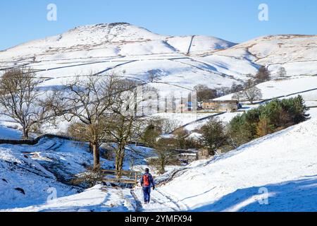 Homme marchant seul à dos dans un paysage hivernal couvert de neige du Cheshire Peak District dans Cumberland Brook, Wildboarclough, vers Shutlingsloe Hill Banque D'Images