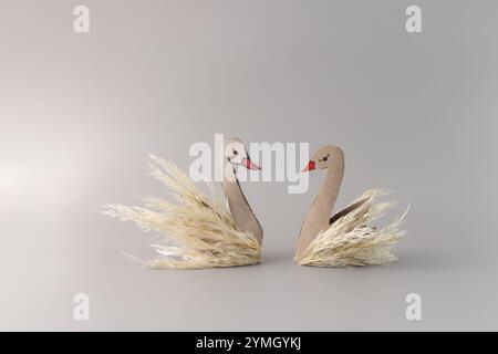 couple de cygnes, personnages amusants fabriqués par l'enfant à partir de matériaux de la nature et rouleau de papier recyclé, artisanat d'automne pour les enfants d'âge préscolaire Banque D'Images