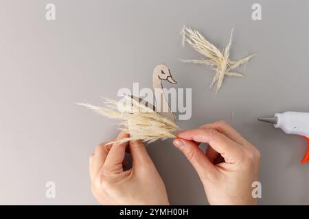 étape dans le processus créatif, artisanat de cygne en herbe sèche et rouleau de papier toilette vide, projet d'art de recyclage, activité pour les enfants d'âge préscolaire et les jeunes enfants, top Banque D'Images