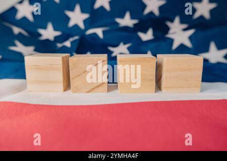 Quatre blocs de bois sont placés sur un drapeau américain rouge, blanc et bleu. Le drapeau est l'arrière-plan de l'image. Les blocs sont disposés de manière à ce que Banque D'Images