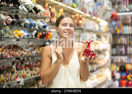 La touriste féminine choisit la figurine de danseuse espagnole dans la boutique de souvenirs Banque D'Images