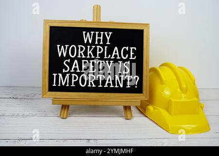 Pourquoi la sécurité sur le lieu de travail est-elle importante? texte sur tableau noir avec casque de sécurité sur fond en bois Banque D'Images