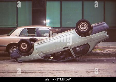 La Nouvelle-Orléans, LOUISIANE, États-Unis - 30 août 2005 : voiture retournée sur son capot par le vent de l'ouragan Katrina dans la rue du centre-ville près du Superdome. Cette photo a été prise avec un appareil photo 35 mm le matin après le passage de l'ouragan. La rue n'avait pas encore été inondée par les digues brisées, mais elle le serait plusieurs heures plus tard. Banque D'Images