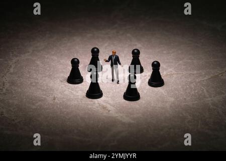 Photographie miniature de personnages jouet. Concept de décision stratégique. Un homme d'affaires debout au milieu du pion d'échecs avec fond d'humeur sombre. Imag Banque D'Images