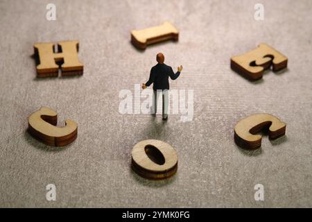 Photographie miniature de personnages jouet. Vue arrière homme d'affaires debout entre l'alphabet de CHOIX. Photo d'image Banque D'Images