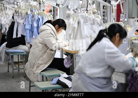 SUQIAN, CHINE - 22 NOVEMBRE 2024 - des travailleurs produisent des chemises sur une chaîne de montage dans un atelier de production intelligent dans une usine de vêtements à Suqian, Jiangsu Banque D'Images