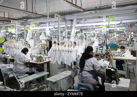 SUQIAN, CHINE - 22 NOVEMBRE 2024 - des travailleurs produisent des chemises sur une chaîne de montage dans un atelier de production intelligent dans une usine de vêtements à Suqian, Jiangsu Banque D'Images