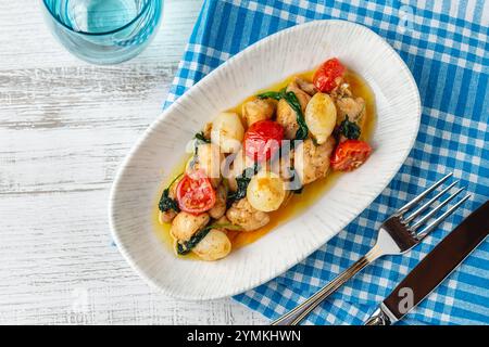 Apéritif avec des crevettes, des oignons et des tomates sur une assiette en porcelaine blanche Banque D'Images