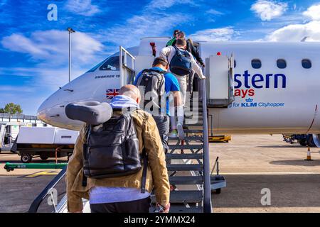 Passagers avec bagage à main embarquant sur le vol KLM Eastern depuis l'aéroport international de Teesside, Darlington, comté de Durham, Angleterre, Royaume-Uni Banque D'Images