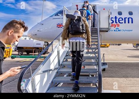 Passagers avec bagage à main embarquant sur le vol KLM Eastern depuis l'aéroport international de Teesside, Darlington, comté de Durham, Angleterre, Royaume-Uni Banque D'Images