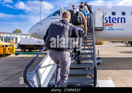 Passagers avec bagage à main embarquant sur le vol KLM Eastern depuis l'aéroport international de Teesside, Darlington, comté de Durham, Angleterre, Royaume-Uni Banque D'Images