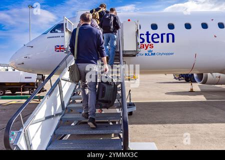 Passagers avec bagage à main embarquant sur le vol KLM Eastern depuis l'aéroport international de Teesside, Darlington, comté de Durham, Angleterre, Royaume-Uni Banque D'Images