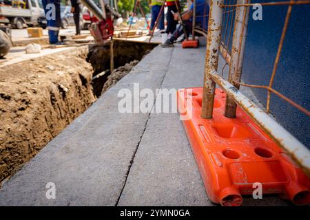 Pied de clôture en plastique est pour la stabilité des panneaux de clôture en fil métallique temporaires, installés devant le chantier à côté de la rue. Banque D'Images