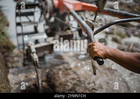 Vue rapprochée d'un agriculteur qui utilise habilement un tracteur dans un champ agricole Banque D'Images