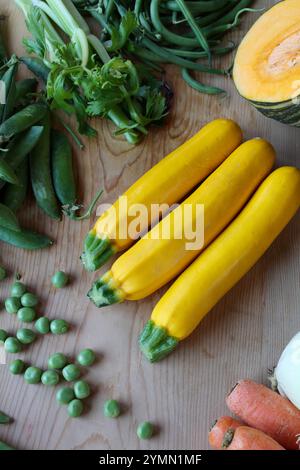 vue rapprochée de courgettes jaunes sur table en bois entre d'autres légumes, fond de nourriture. Nature morte dans la cuisine Banque D'Images