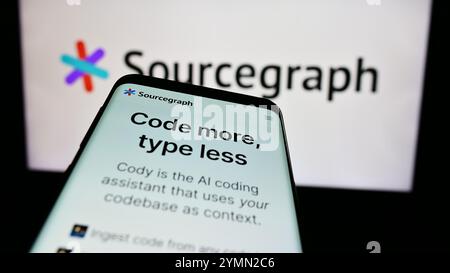 Dans cette illustration photo, un téléphone portable avec la page Web de la société américaine de renseignement de code Sourcegraph Inc est vu devant le logo de l'entreprise. Banque D'Images