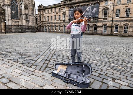 Une jeune fille asiatique qui joue du violon (Tafatele Music) à Parliament Square, Royal Mile, Édimbourg, Écosse, Royaume-Uni Banque D'Images