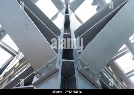 Colonne en métal gris et poutres reliées par des boulons, photo en gros plan. Photo de fond d'architecture industrielle abstraite avec flou sélectif Banque D'Images