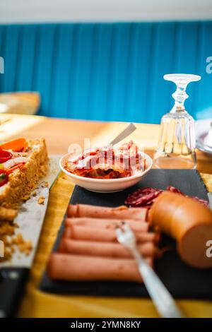Un tableau de charcuterie dynamique avec des viandes variées, du fromage et des délices salés. Parfaitement disposé sur une table rustique, capturant l'essen Banque D'Images