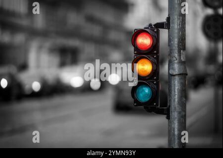 Un feu de circulation à une intersection indique des feux rouges, jaunes et verts. Banque D'Images