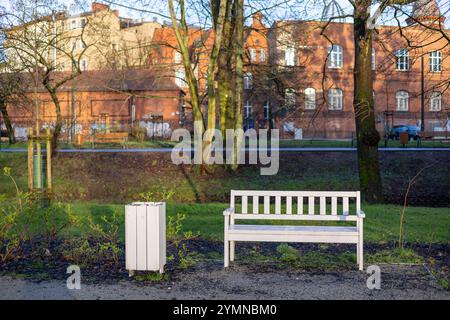 Un banc blanc et une décharge à ordures dans le parc de la ville de printemps. Photo de haute qualité Banque D'Images