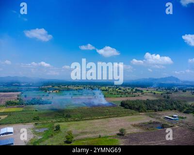 Vue aérienne d'agriculteurs brûlant des résidus de maïs après la récolte. Feu de champ de maïs après la récolte. Banque D'Images