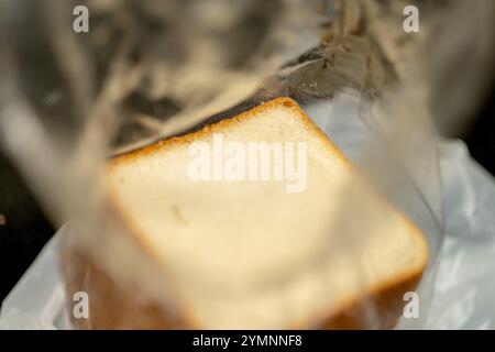 Tranche de pain fraîchement cuite, partiellement visible à travers l'emballage en plastique transparent. Prêt pour un délicieux sandwich ou pain grillé. Banque D'Images