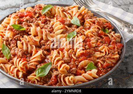 Pâtes italiennes Fusilloni avec viande hachée, sauce tomate et légumes gros plan sur l'assiette sur la table. Horizontal Banque D'Images