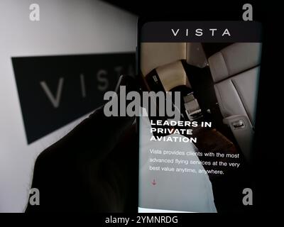 Dans cette illustration photo, une personne tient un téléphone portable avec la page Web de la société d'aviation émiratie Vista Global Holding Limited devant le logo. Banque D'Images