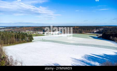 Bavière, Allemagne - 22 novembre 2024 : vue aérienne d'un champ agricole enneigé entouré de forêt *** Luftaufnahme eines schneebedeckten landwirtschaftlichen Feldes, umgeben von Wald Banque D'Images