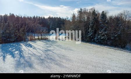 Bavière, Allemagne - 22 novembre 2024 : vue aérienne d'un champ agricole enneigé entouré de forêt *** Luftaufnahme eines schneebedeckten landwirtschaftlichen Feldes, umgeben von Wald Banque D'Images