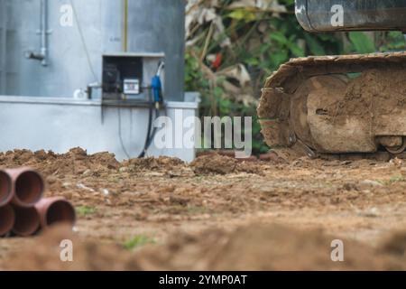 Une grande machine de chantier est stationnée sur un champ de terre battue. La saleté est brune et la machine est assez grande, occupant une partie importante du champ Banque D'Images