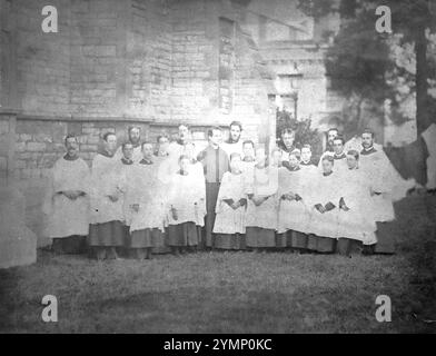 1879, Christ Church, Newtown, Alverstoke, Gosport, Hampshire, Angleterre. Une photographie de groupe victorienne et le curé de la paroisse et d'autres, peut-être le chœur masculin, debout dans le terrain de cette église. L'image originale est très délavée et sépia ton - j'ai converti en niveaux de gris dans l'espoir de faire ressortir plus de détails. Banque D'Images