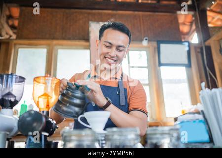 barista masculin asiatique travaillant dans un petit café Banque D'Images