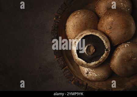 Champignons Portobello frais, dans un bol en bois, vue de dessus, gros plan, personne Banque D'Images