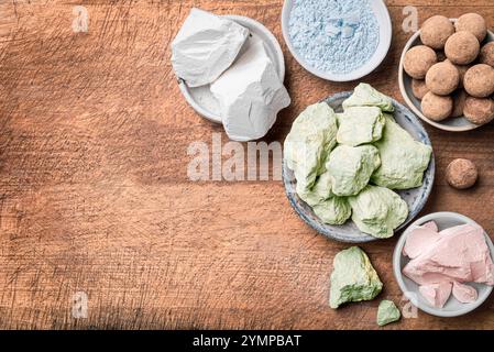Comestibles diverses pierres d'argile, roches d'argile et poudre sur fond de bois, vue de dessus, espace de copie. Craie ou argile comestible naturelle, snack tendance. Banque D'Images
