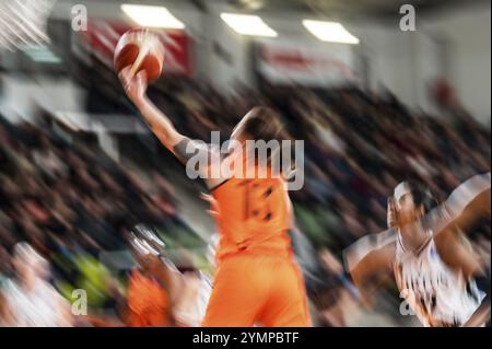 Une joueuse jette le ballon dans le panier pendant le match de basket-ball. Image avec défaut intentionnel (tatouage sur le bras également taché) Banque D'Images
