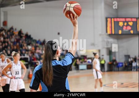 Une femme arbitre garde le ballon pendant le match de basket-ball. Banque D'Images