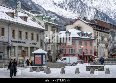 Un groupe de personnes marchant dans une rue enneigée après la première neige à Chamonix, dans les Alpes françaises. Banque D'Images