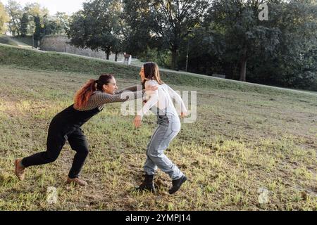 Deux amies jouissant d'un moment ludique dans un parc, courant et riant ensemble Banque D'Images