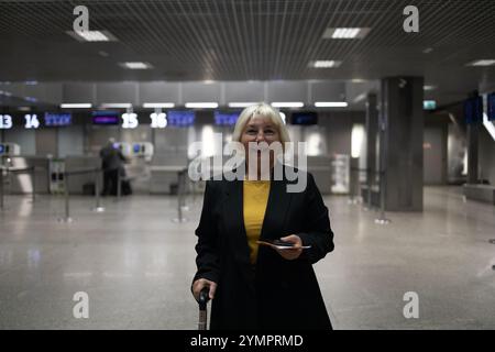 Femme adulte voyageant avec des bagages à main, sac à dos tient le passeport et attend le voyage de vol à l'aéroport international terminal. Femme d'âge moyen Go Banque D'Images
