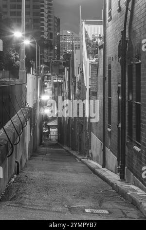 La banlieue de Sydney de The Rocks, établie lors de la colonisation en 1788, contient de nombreux sites classés au patrimoine et est la plus ancienne banlieue d'Australie. Ses bâtiments, escaliers et arcades ont été construits avec du grès local, d'où le nom de la région. Jusqu'aux années 1870, c'était un bidonville où les « gangs de rasoirs » flânaient la nuit dans les ruelles. C'est maintenant un quartier touristique chargé d'histoire entouré de Dawes point, Millers point et Barangaroo, souvent considéré comme faisant partie du quartier des Rocks. Sur la photo : une vue nocturne regardant vers le sud le long d'Argyle Lane à Millers point dans les Rocks, vu depuis Argyle place. Banque D'Images