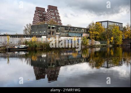 Maisons, industrie abandonnée et bateaux reflétant dans le canal du marché occidental à Amsterdam, pays-Bas, nov 15, 2024 Banque D'Images