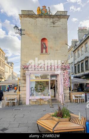 Sweet Little Things café festonné de fleurs roses et couronne de Noël avec staue de Putto et Royal Coat of Armoiries sur le bâtiment ci-dessus à Bath, Royaume-Uni sur 22 Nove Banque D'Images