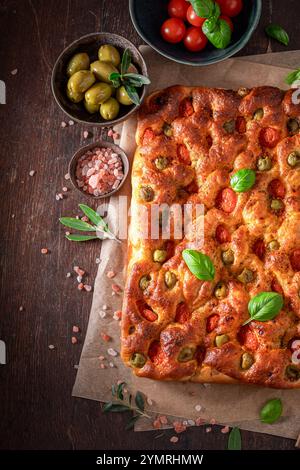 Focaccia chaude à base de basilic et tomates cerises. Affiche pour le restaurant. Focaccia aux olives et tomates. Banque D'Images