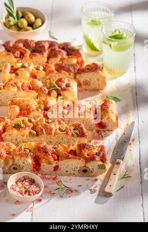 Focaccia savoureuse et maison fraîchement cuite et servie avec de la limonade. Affiche pour le restaurant. Focaccia au salami et au fromage. Banque D'Images