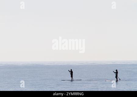 Les paddle-boarders de la célèbre plage de Malibu attendent pour entrer dans l'eau par une chaude journée de fin d'été. Banque D'Images