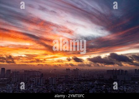 Un horizon urbain avec un beau ciel orange et rose. Le ciel est rempli de nuages et le soleil se couche Banque D'Images