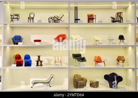 Weil am Rhein, Bade-Wurtemberg, Allemagne. 3 décembre 2022. Des miniatures de chaises design exposées dans la vitrine du Vitra Museum à Weil am Rhein, en Allemagne, retracent l'histoire du design. De gauche à droite sur l'étagère supérieure : Gartenstuhl de Karl Friedrich Schinkel, Stuhl no 14 de Michael Thonet & sons, Schaukelsessel no 9 de J. & J. Kohn, Hill House 1 de Charles Rennie Mackintosh, Barrel chair de Frank Lloyd Wright et Sitzmaschine de Josef Hoffmann. Sur le deuxième plateau le plus haut : chaise Taliesin West de Frank Lloyd Wright, chaise Womb & Ottoman de Eero Saarinen, la chaise, RAR et DSW b Banque D'Images